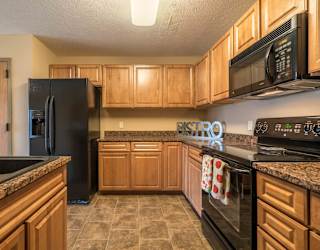 a kitchen with black appliances and wooden cabinets