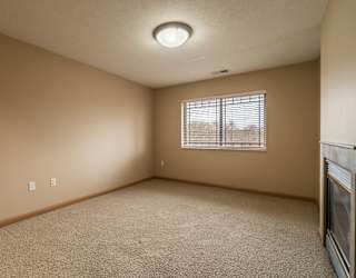 an empty bedroom with a window and carpet