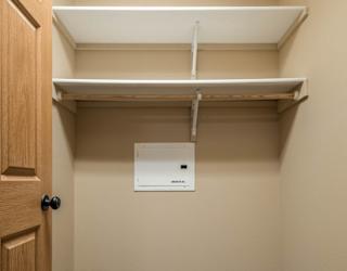 a empty closet with a door and a paper towel dispenser