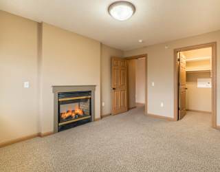 an empty bedroom with a fireplace