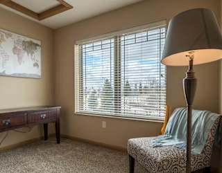 a living room with a lamp and a chair and a window