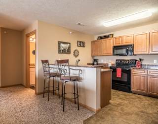 a kitchen with a bar with three stools