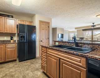 a kitchen with wooden cabinets and a black refrigerator