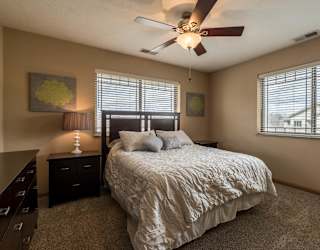 a bedroom with a bed and a ceiling fan