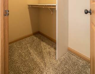 a walk in closet in a home with a door open