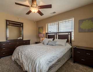 a bedroom with a large bed and a ceiling fan