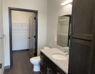 Bathroom with cabinet storage, light counters, and a connected walk in closet