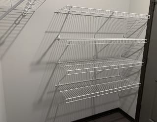 Walk in closet with one full wall of wire wracks for storage and hanging