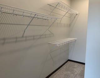 Walk in closet with one full wall of wire wracks for storage and hanging