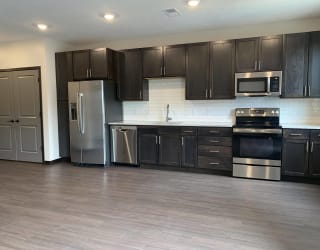 Open kitchen with matching stainless steel appliances in Peace floorplan at Haven at Uptown