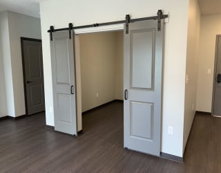 Den or office space with elegant double barn doors at Haven at Uptown