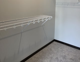 Walk-in closet with shelving and rods in the Peace floorplan at Haven at Uptown