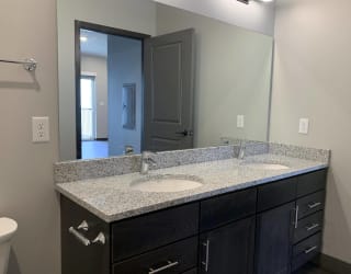 Bathroom with dark brown double vanity with storage and large mirror