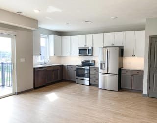 Spacious open kitchen with matching steel appliances and under cabinet lighting