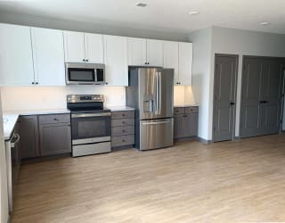 Spacious open kitchen with matching steel appliances and under cabinet lighting in serenity floorplan at Haven at Uptown
