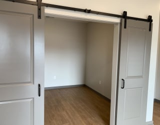 Sliding gray barn doors to the spacious office area or den