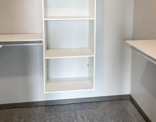 All white shelving and rods in walk in closet in serenity floor plan at Haven at Uptown