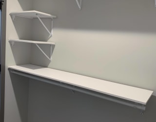 All white shelving and rods in walk in closet in serenity floor plan at Haven at Uptown