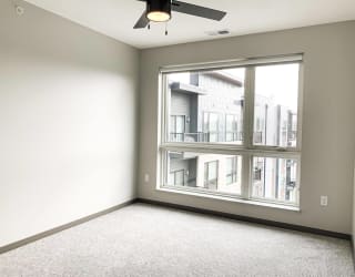 Carpeted bedroom with large floor to ceiling window