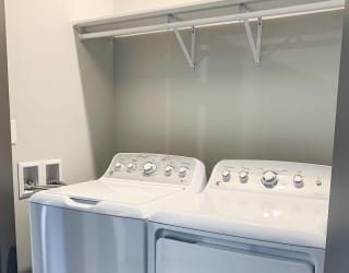 In unit laundry washer and dryer in closet with shelf for storage