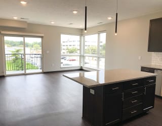 Living room and kitchen view through corner floor to ceiling windows and sliding door that look out onto north Lincoln, Nebraska