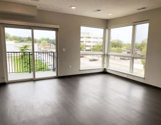 Living room view through corner floor to ceiling windows and sliding door that look out onto north Lincoln, Nebraska