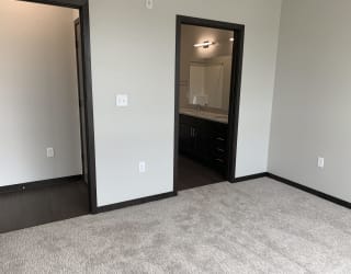 Bedroom with a doorway into the connected bathroom and a door into the hallway