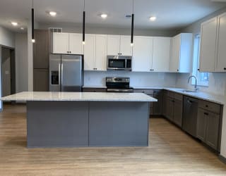 Kitchen with white cabinets and floating island at haven at uptown in lincoln nebraska