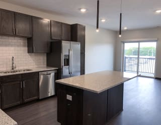 kitchen with lots of storage cabinets in a warm mocha finish at Haven at Uptown