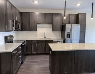 kitchen with lots of storage cabinets in a warm mocha finish at Haven at Uptown