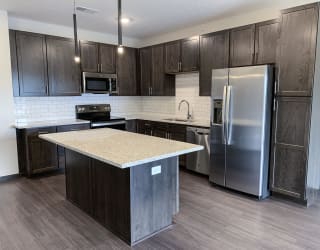 kitchen with lots of storage cabinets in a warm mocha finish at Haven at Uptown