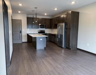 Living area looking into connected kitchen with island at Haven at Uptown