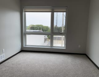 Open bedroom with large floor to ceiling window looking outside to north Lincoln