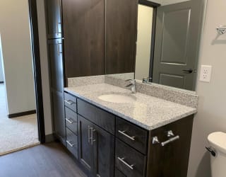 bathroom with warm brown cabinets and lots of cabinet and linen storage