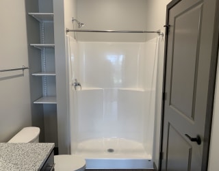 bathroom with warm brown cabinets and lots of cabinet and linen storage