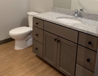 Bathroom with light brown cabinetry and granite counter tops