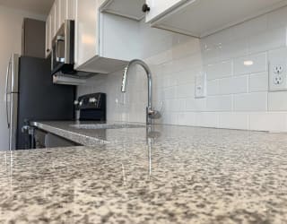 Close up of light granite counters and white subway tile backsplash