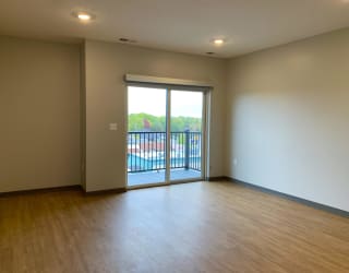 Open living room open dining room with sliding glass door to balcony at Haven at Uptown in Lincoln, Nebraska