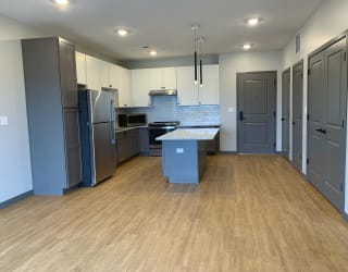 Open kitchen to dining room with large granite countertop island at Haven at Uptown in Lincoln, Nebraska