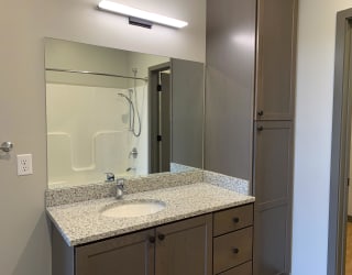 spacious bathroom with large mirror in light gray finish at Haven at Uptown in Lincoln, Nebraska