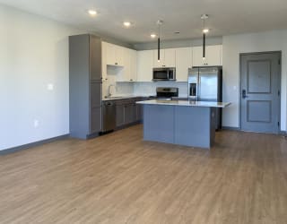 Kitchen with white upper cabinets and gray lower cabinets at Haven at Uptown