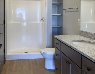 Large bathroom with standing shower and storage shelves at Haven at Uptown