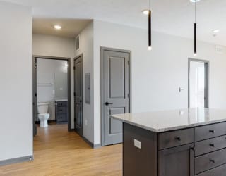 View of kitchen island and hallway leading to the bathroom in the Bliss floor plan at Haven at Uptown in Lincoln, NE