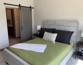 a bedroom with a bed and a closet with sliding barn door