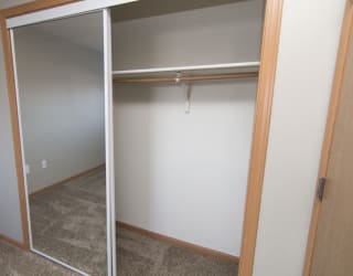 an empty closet in a room with a mirrored door