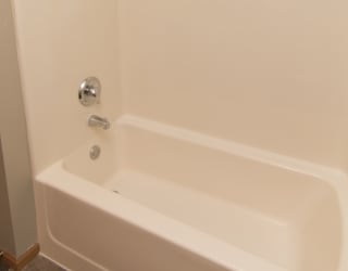 a white bath tub in a bathroom with a shower curtain
