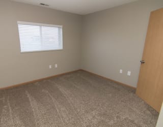 an empty room with carpet and a window