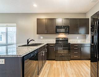 Kitchen with hardwood-like flooring and GE appliances at The Villas of Omaha at Butler Ridge in Omaha Nebraska