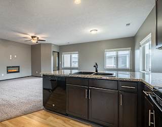 A kitchen that opens up to a large living space at the Villas of Omaha at Butler Ridge in Omaha Nebraska