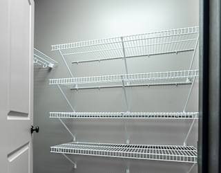 Empty walk-in closet with shelves and carpeted floor.